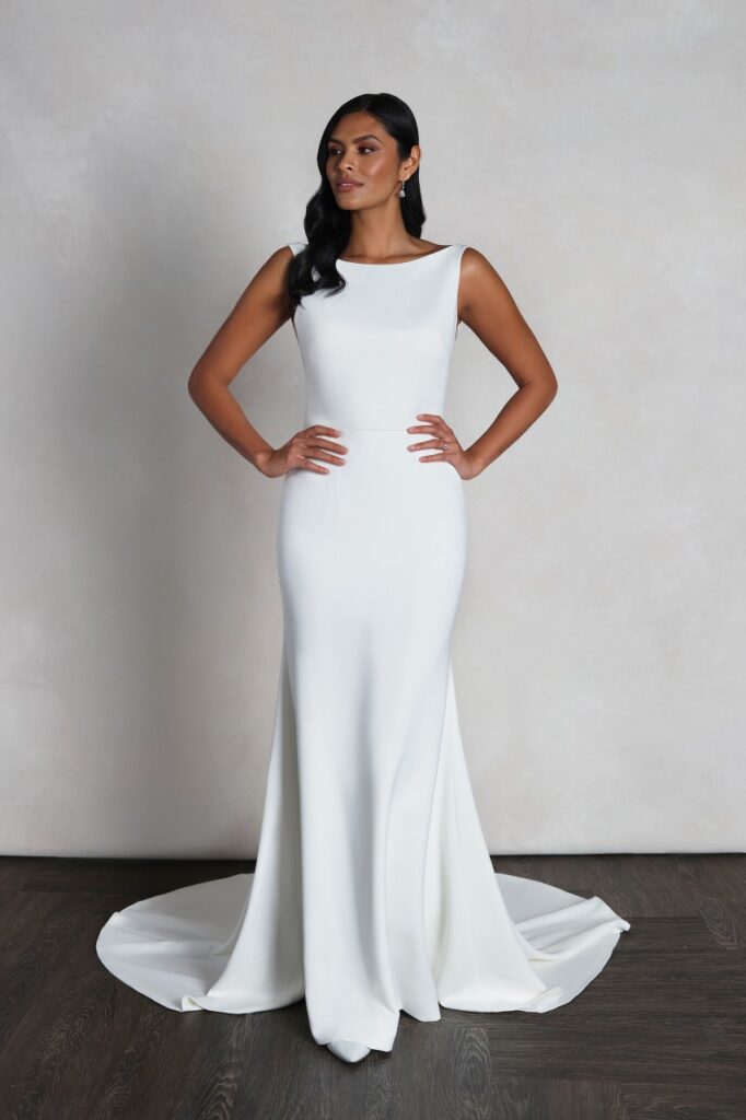 55143-Pure Bridal. Crepe fit and flare with Sabrina neckline, deep V-side illusion insets, and square back. Finished with invisible zipper and crepe covered buttons extending to end of chapel length trainEdmonton wedding shop, Edmonton bridal shop, Edmonton wedding dress.