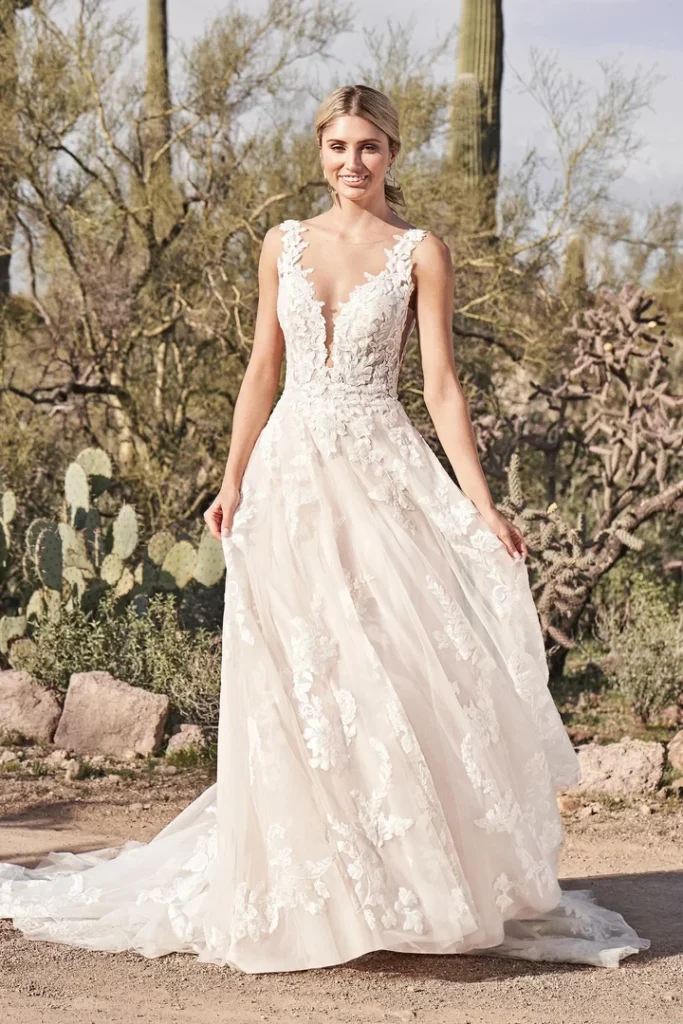 Lillian West Style 66163 is a Soft, romantic lace details this tulle A-line wedding gown. Featuring an illusion Sabrina neckline with a plunge, side cutouts, and sexy scoop back. A Chantilly lace underlay in the bodice blends with sequined embroidered appliqu&eacute;s that gracefully cascade throughout the skirt and train. Hidden tulle pockets in the skirt are the finishing touch. Available in Plus Size. Available at Pure Bridal Edmonton.