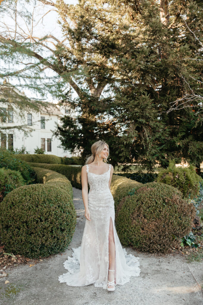 7941-Stella York-Pure Bridal, SCOOP NECK TULLE WEDDING DRESS WITH SPAGHETTI STRAPS The mesmerizing Style 7941 shimmers down the aisle with an extravagant display of embellished glitter tulle and floral lace. The sparkly fit-and-flare wedding dress features romantic lace spaghetti straps that dip into a flattering scoop neckline. The fitted bodice is available with split options to pair with the sultry lace side cutouts and the lacy low illusion back detail. From the waist, handcrafted lace appliqués scatter across the glittering fit-and-flare skirt, with an optional leg slit for added charm. Culminating in a beautiful shaped train, this exquisite scoop neck fit-and-flare wedding gown makes a glamorous statement on that special day. This gown is available without or without a glitter tulle skirt, Edmonton wedding shop, Edmonton wedding dress