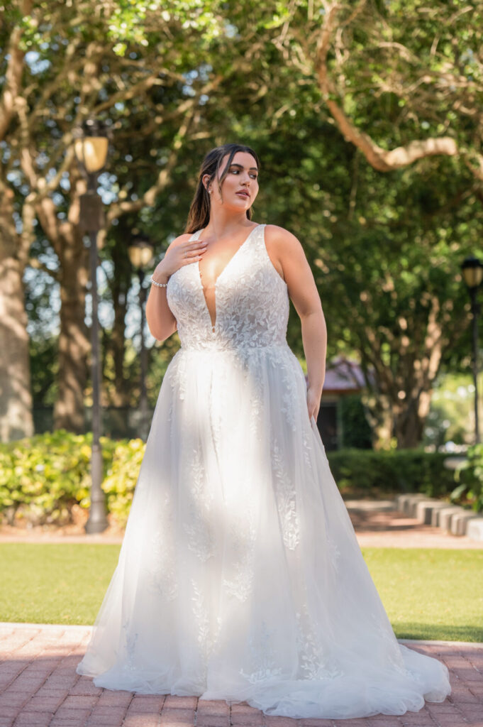 D4007-Essense of Australia-Pure Bridal, ETHEREAL LACE, ORGANZA AND TULLE A-LINE WEDDING DRESS WITH PLUNGING NECKLINE Sparkling down the aisle, Style D4007’s dreamy leafy floral lace and organza over optional glitter tulle captures the ethereal essence of this romantic A-line wedding gown. Lace-embellished shoulder straps frame a plunging V-neckline topping the sheer, glittering bodice. Leafy tendrils and sparkling floral accents scatter from the bodice to the frothy tulle A-line skirt, evoking a wistful, dreamlike effect. With each step, the glittering tulle catches the light, shimmering for the modern romantic’s walk down the aisle. This gown is also available in plus sizes, Edmonton bridal shop, Edmonton wedding shop, Edmonton wedding dress