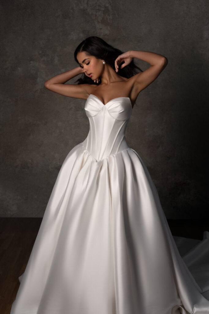 Essense of Australia Style D4410 strapless Mikado ballgown wedding dress featuring a cat eye neckline, exposed boning bodice, and long drop waist, available with a tie-up back or zipper closure at Pure Bridal in Edmonton.