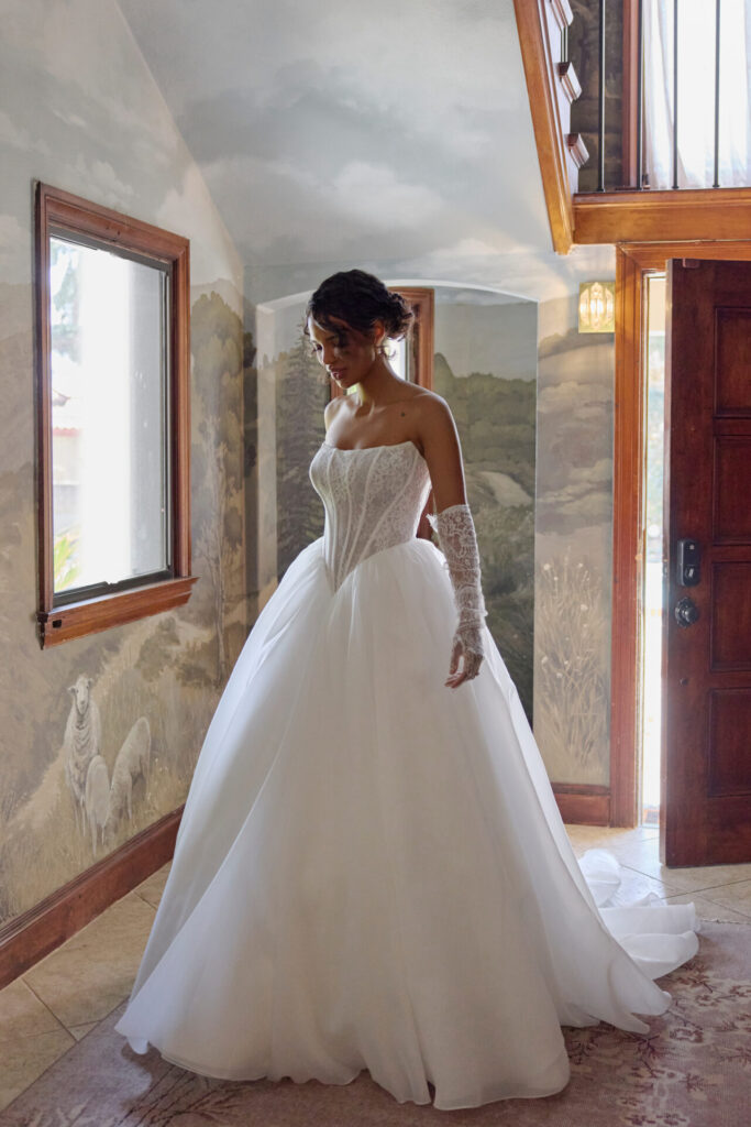 Essense of Australia Style D4458 ballgown wedding dress featuring a strapless scoop neckline, a sheer lace bodice with delicate transparency and an extreme basque waist organza skirt at Pure Bridal in Edmonton.