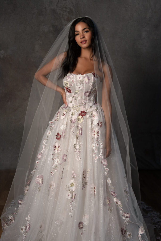 Essense of Australia Style D4482 strapless A-line wedding dress with a slight basque waist, exposed corset bodice, and colorful embroidered floral lace, also available lined, without glitter, or in all ivory at Pure Bridal in Edmonton.