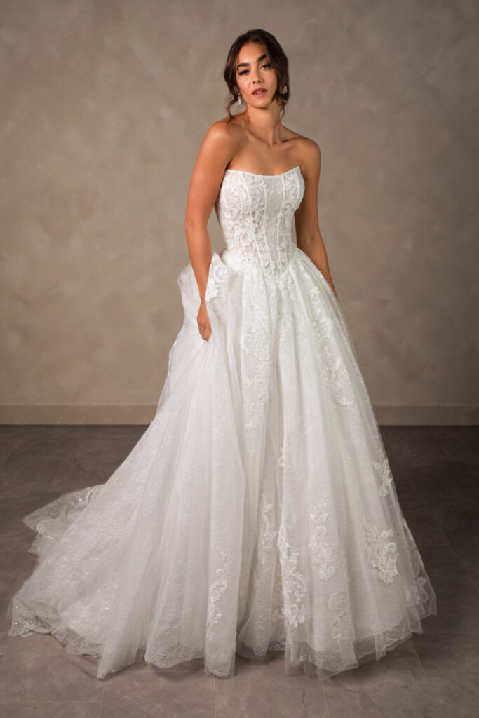 Essense of Australia style D4553 Tulle and lace ballgown wedding dress, featuring a structured corset bodice with a cat eye neckline, exposed boning, and basque waistline. Available with lined or unline bodice and in plus sizes at Pure Bridal in Edmonton