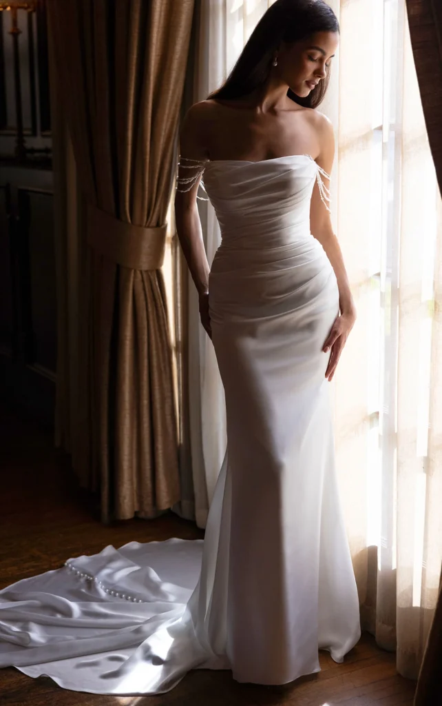 Discover the romantic Style D4607 by Essense of Australia at Pure Bridal in Edmonton. This elegant strapless column gown features luminous charmeuse and delicate pearl detailing. Book your bridal appointment today to try on this stunning design.